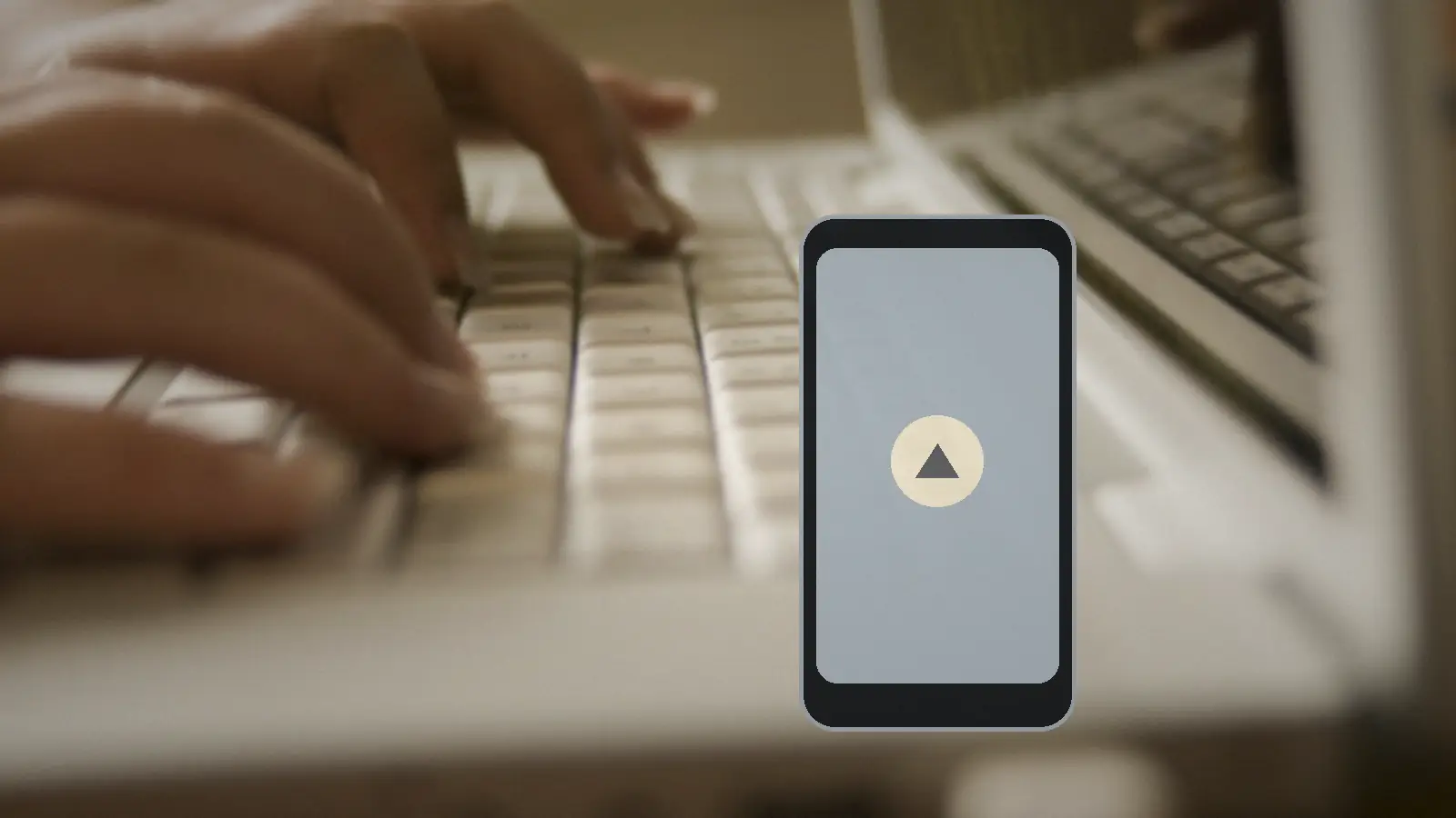 Смартфон с предупреждающим символом лежит рядом с клавиатурой ноутбука